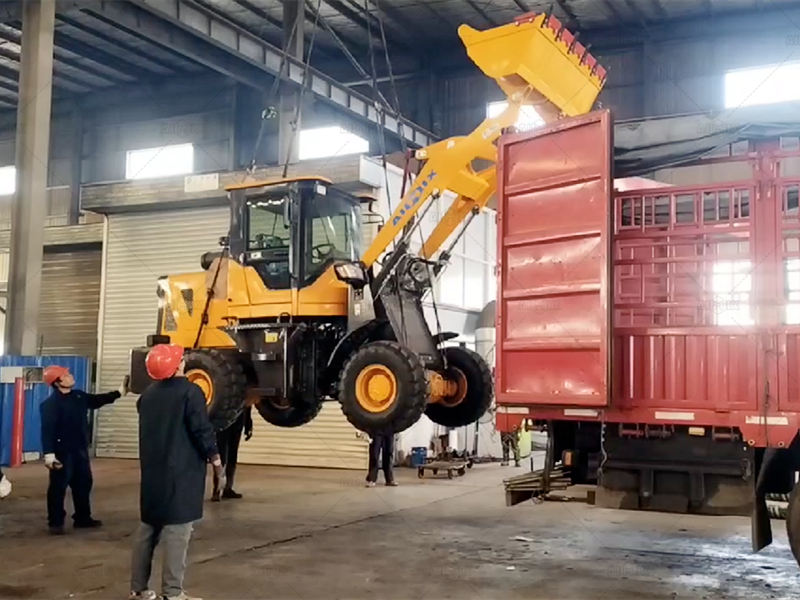 wheel loader being lifted to put in the truck